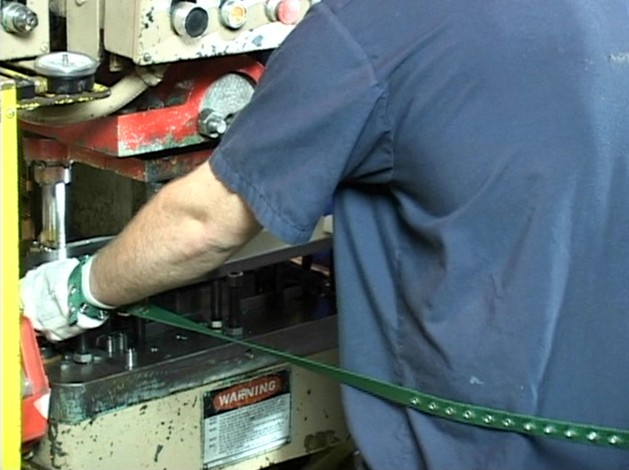 A machinist properly using a machine guard or safety device to avoid machine guarding hazards