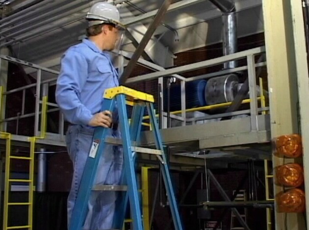 A worker using proper safety precautions and following safe work practices while using a ladder