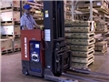 A warehouse worker safely operating a reach truck avoiding injury by following safe work practices