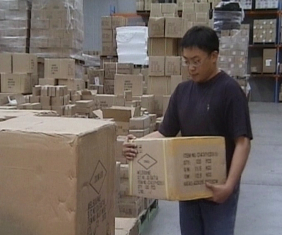 A warehouse worker lifting a box using the proper lifting technique to prevent back injuries