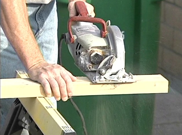 A worker using a power tool and following safe work practices to avoid serious injury while at work