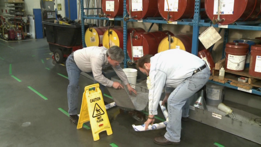 Industrial workers demonstrating good housekeeping practices after a chemical spill in the workplace