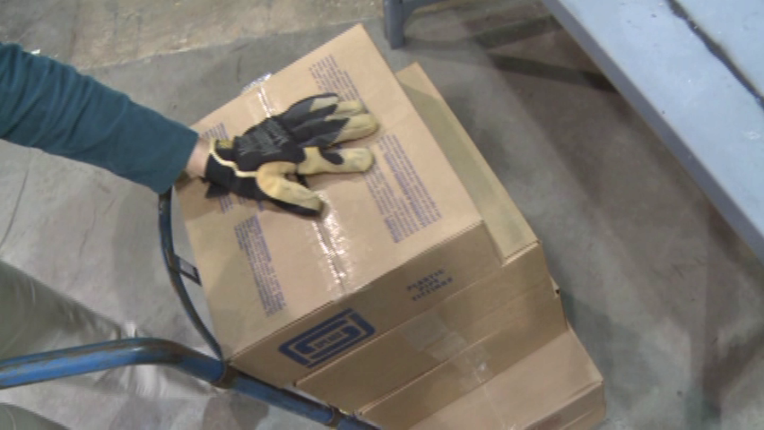 A warehouse worker demonstrating safe material handling techniques to avoid workplace injuries