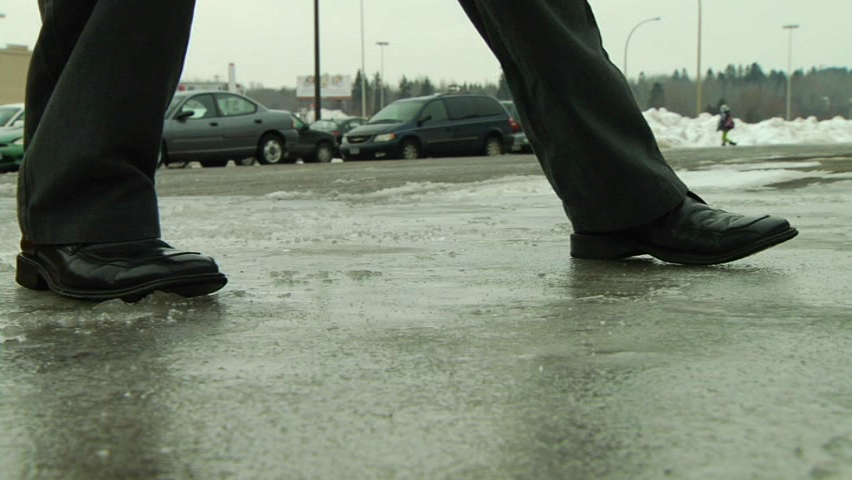 A person attempting to walk safely on ice during winter conditions to avoid injury and stay safe