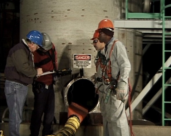 A safety manager training workers on confined space safety to avoid injury from workplace hazards