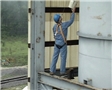 A worker using a personal fall arrest system properly to keep himself safe in case of a fall