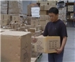 A warehouse worker lifting a box using the proper lifting technique to prevent back injuries