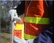 A worker preventing exposure to bloodborne pathogens by following safety training procedures