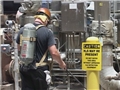 A worker wearing respiratory protection and following the Hydrogen Sulfide Contingency Plan